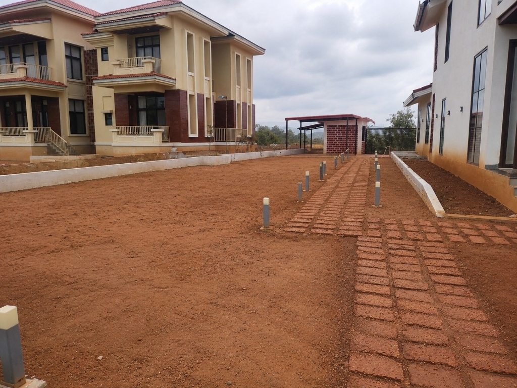 Before — Barren villa compound with red soil